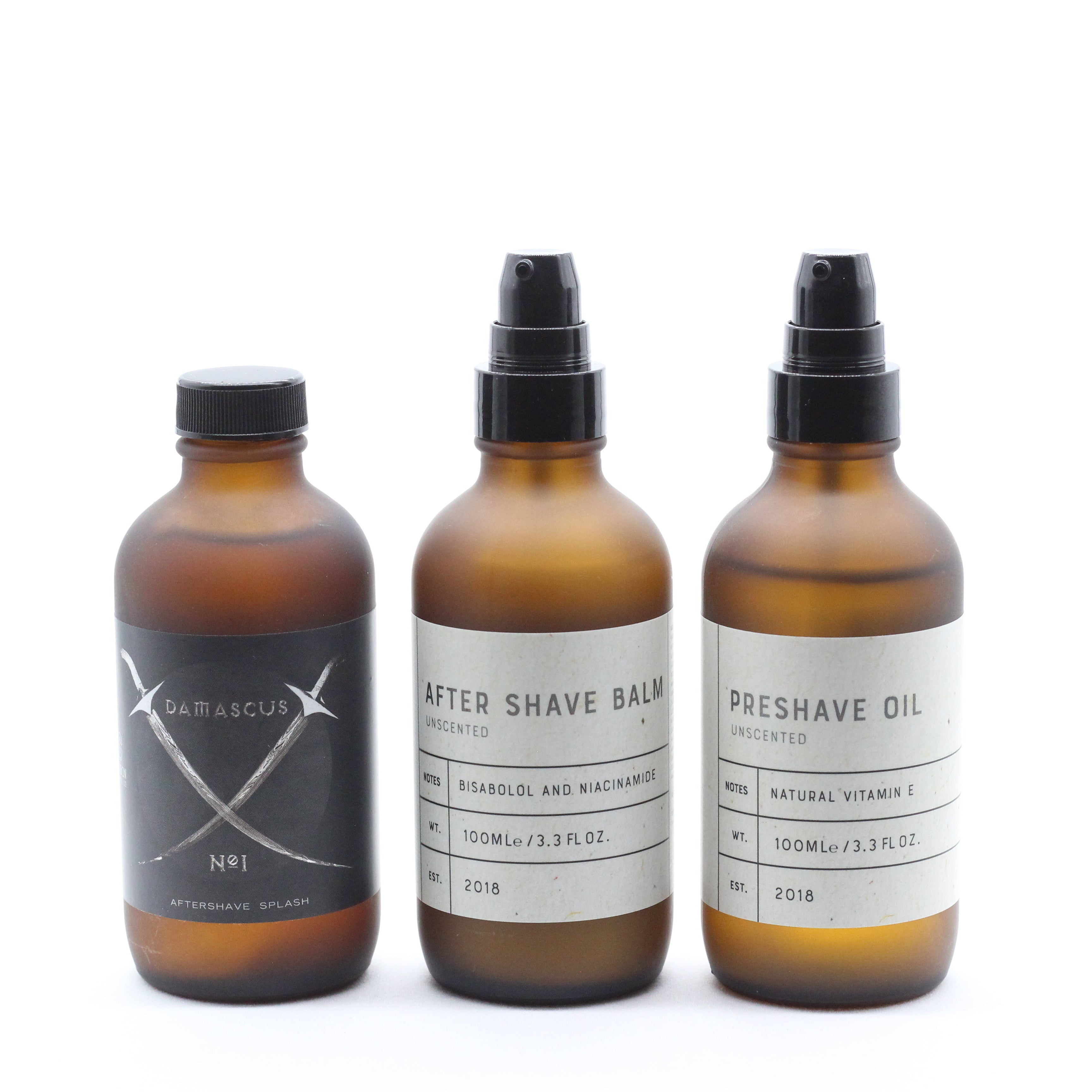 Three amber glass bottles labeled 'After Shave Balm', 'Preshave Oil', and 'after shave balm' on a white background.