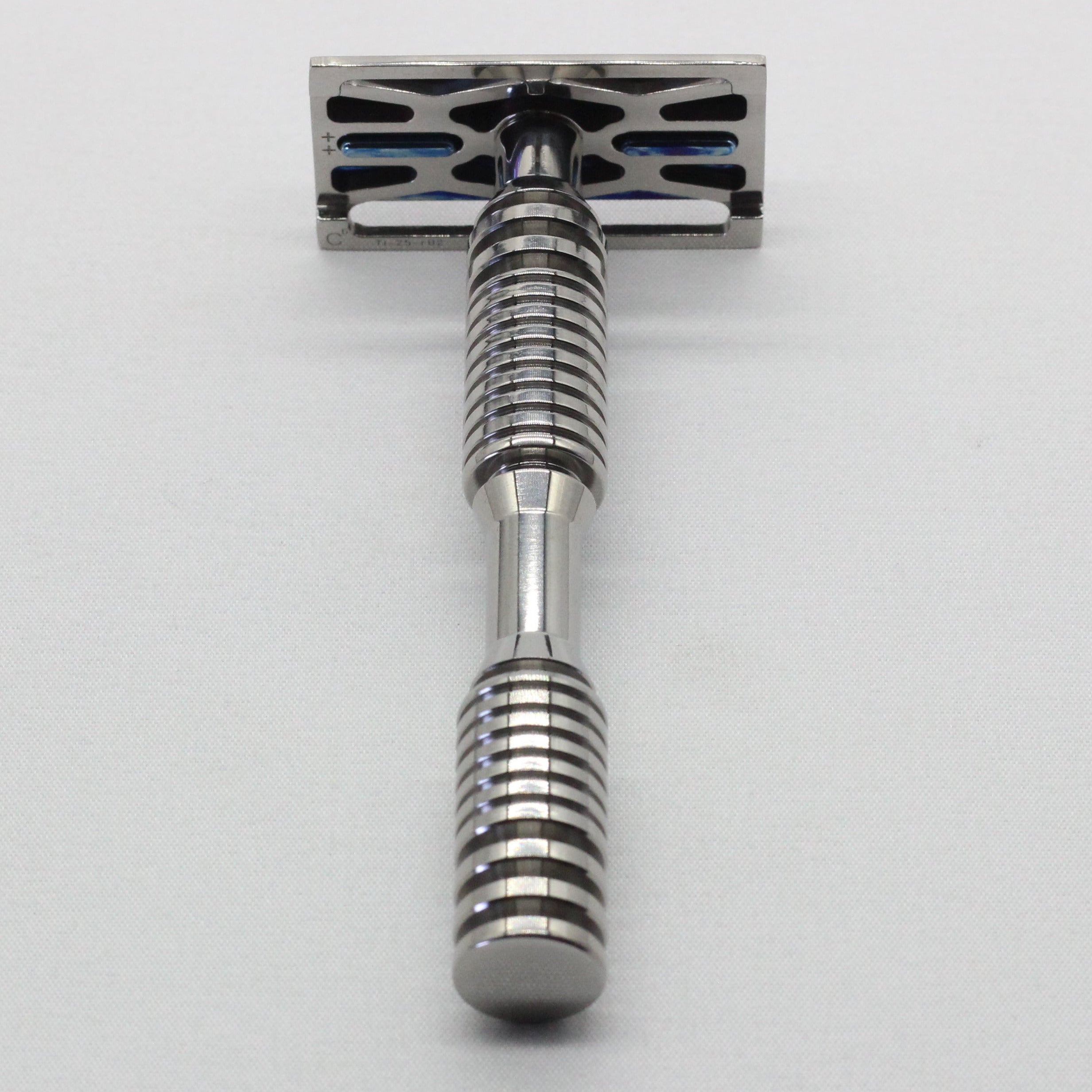 Metallic safety razor on a light gray background
